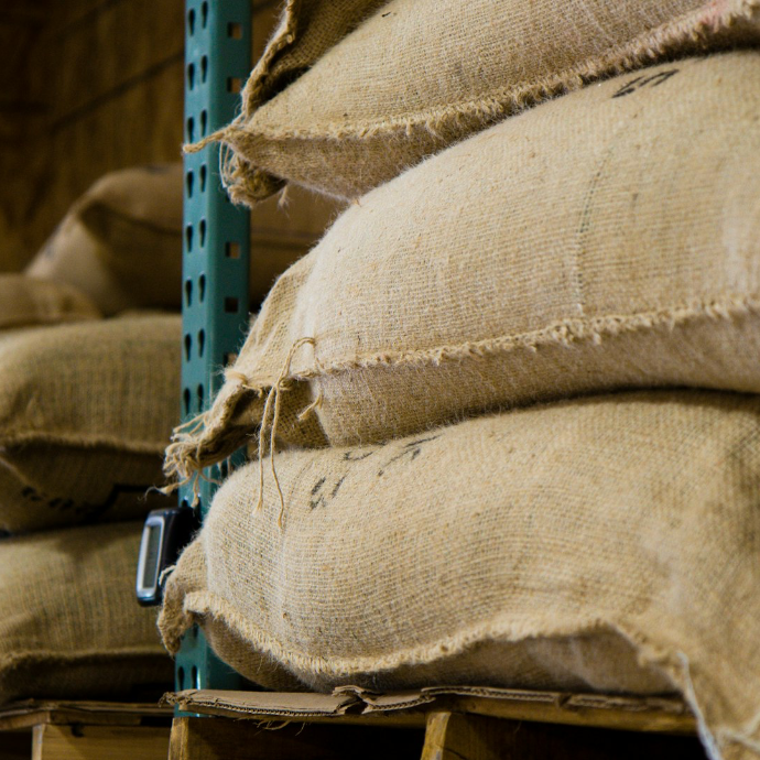 A stack of coffee jute bags stacked  on a warehouse shelf